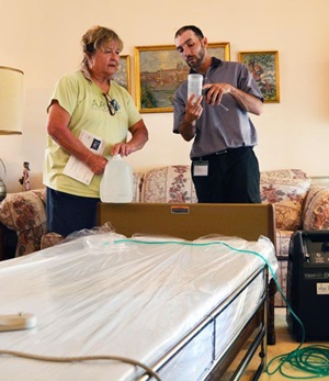 An HME technician shows a caregiver how to use a device