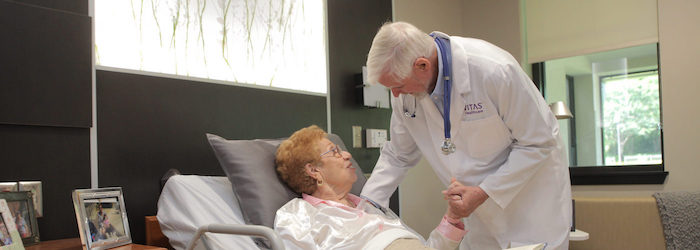 VITAS Physician holding patient's hand