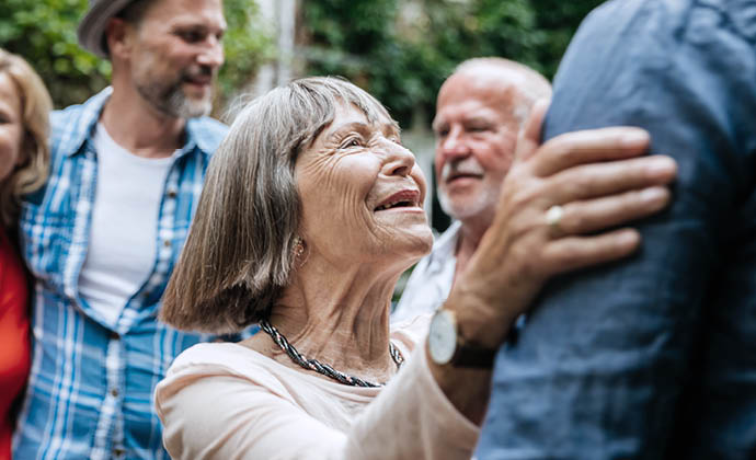 A woman talks and smiles with relatives at a family gathering