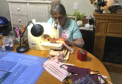 A VITAS volunteer works at her sewing machine to make cloth masks